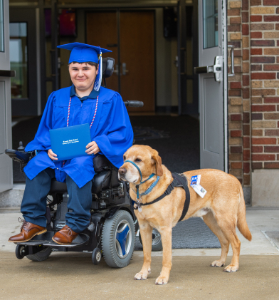 Man in a wheelchair along with his service dog