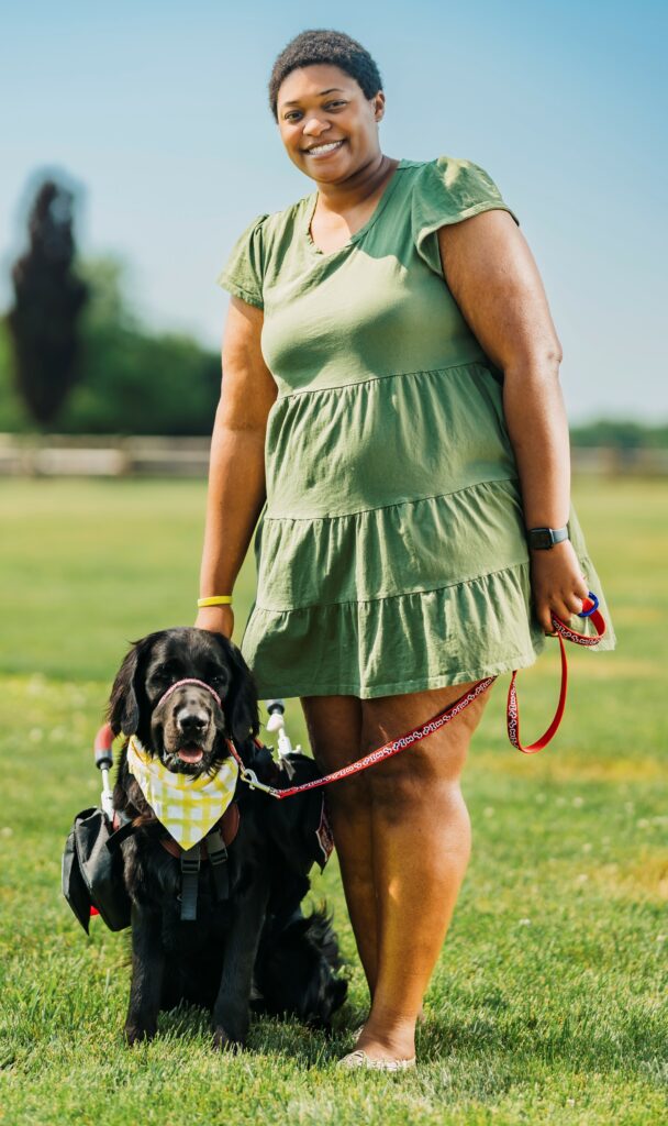 Woman standing besides her service dog 
